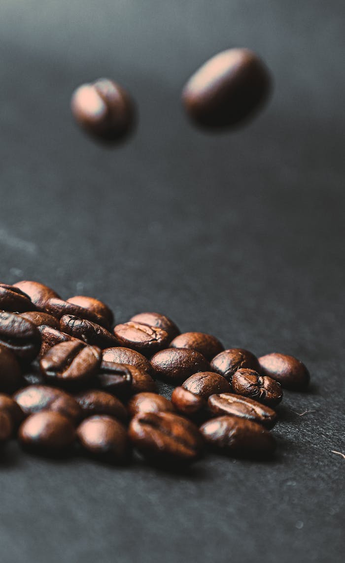 Dynamic shot of roasted coffee beans falling, capturing the essence of freshness.
